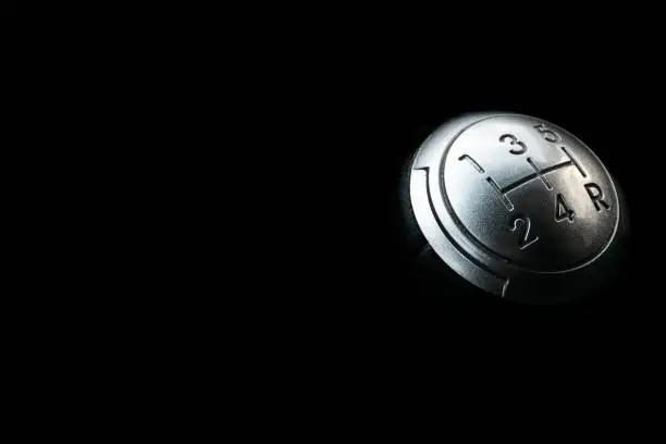 Photo of Close up view of a manual gear lever shift isolated on black background. Manual gearbox. Car interior details. Car transmission. Soft lighting. Abstract view. Car detailing