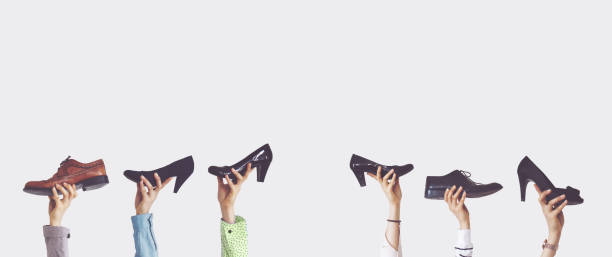 istock Hands holding different shoes on isolated background 1124240904