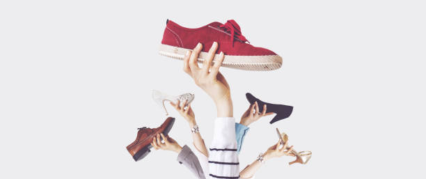 istock Hands holding different shoes on isolated background 1124241479