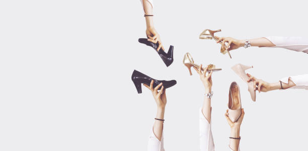 istock Hands holding different shoes on isolated background 1124241486