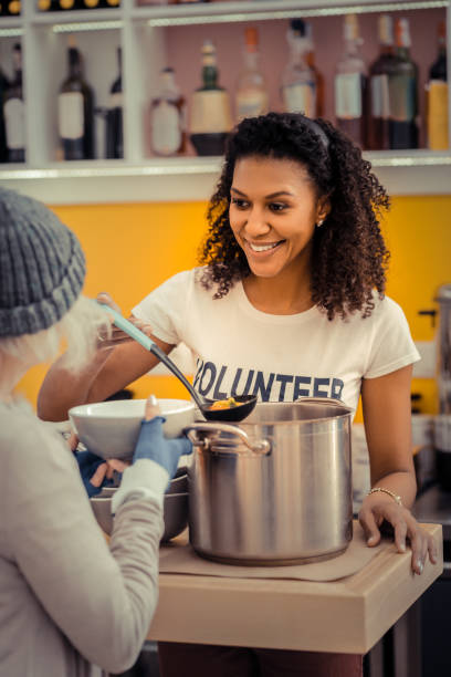 Joyful nice young woman giving the soup