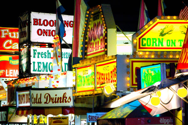 Colorful photo of different food vendors at a carnival or fair.