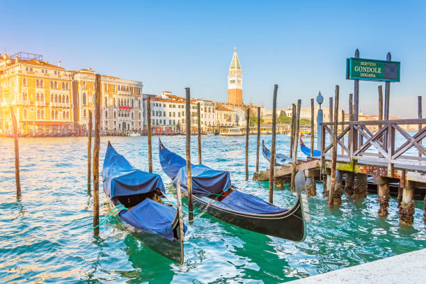 canal grande gondeln an der pier - gondel zolldienst und kirche san giorgio maggiore. - venice italy italy gondola canal stock-fotos und bilder