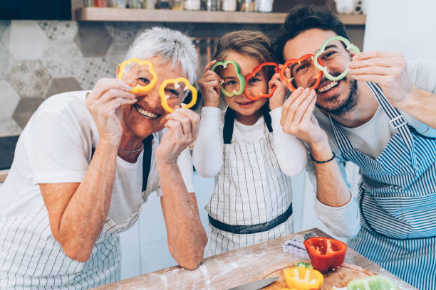 happy multi-generation family in the kitchen - glasses child cute offspring imagens e fotografias de stock