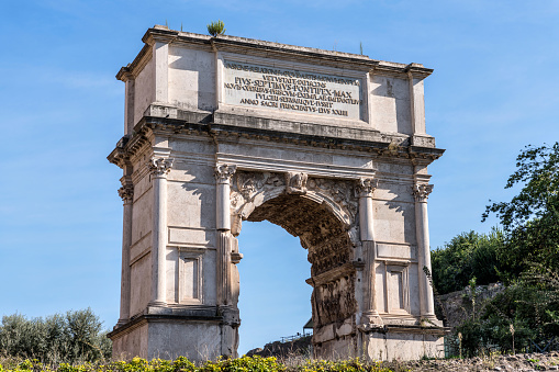 A closeup view of west side of 1st-century triumphal arch, Arch of Titus, in Roman Forum. Rome, Italy. The Latin inscription added in 19th-century to record the restoration ordered by Pope Pius VII.