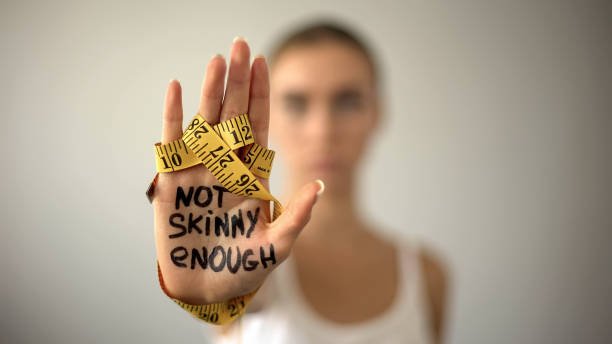 Not skinny enough written on woman palm with tape, severe diet, anorexia Not skinny enough written on woman palm with tape, severe diet, anorexia eating disorder stock pictures, royalty-free photos & images