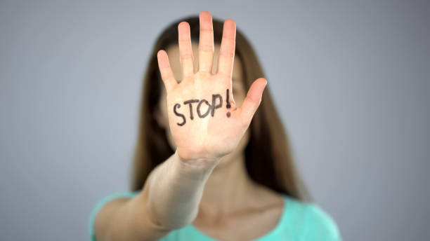 istock Stop sign on womans hands, female rights protection, awareness of problem 1124272830