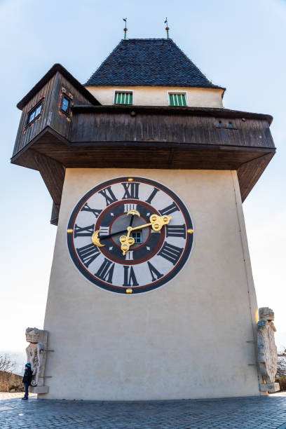 Graz, Styria / Austria - 20.01.2019: View at clock tower on a blue sky. Vertical in winter.