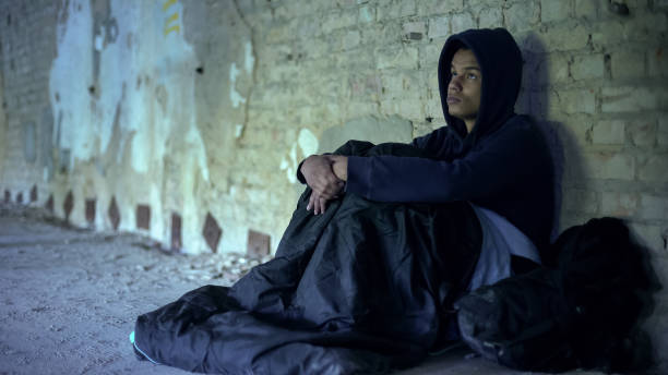 istock Homeless refugee sitting in gateway, preparing to overnight in sleeping bag 1124273057