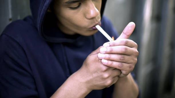 afro-american man exhaling cigarette smoke, felling cool, harming health - harming imagens e fotografias de stock