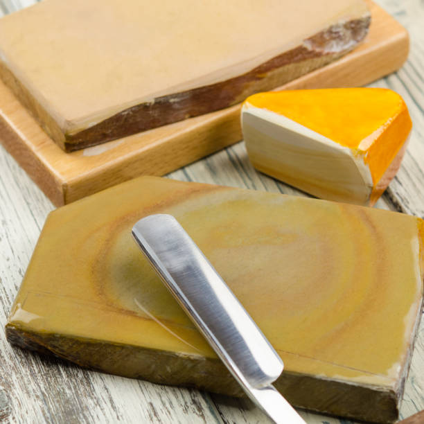 istock Water sharpening stones and cutthroat razor. Razor and sharpening stones on a rustic background. 1124275548