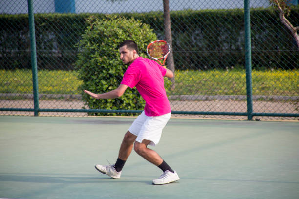 istock Young tennis player hitting the ball 1124277627