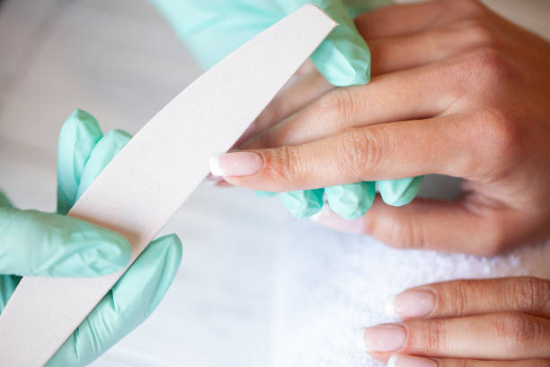 istock Manicure. Skillful master of manicure holding file in her hands while working in her beauty salon 1124279121