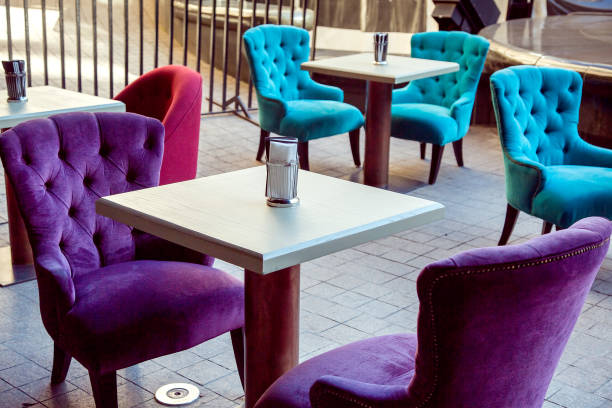 istock outdoor cafe with square white tables and multi-colored soft textile chairs on the stone paving slabs. 1124280987