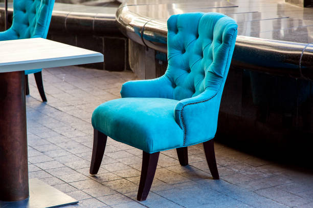 istock An empty armchair sheathed in soft cloth with a high back in blue is standing on the stone tile of the terrace of the summer cafe. 1124280990