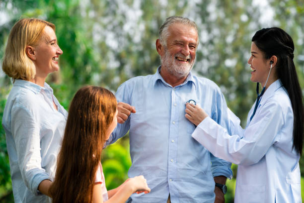 szczęśliwa zdrowa rodzina i lekarz rozmawiający w parku. - doctor old male family zdjęcia i obrazy z banku zdjęć