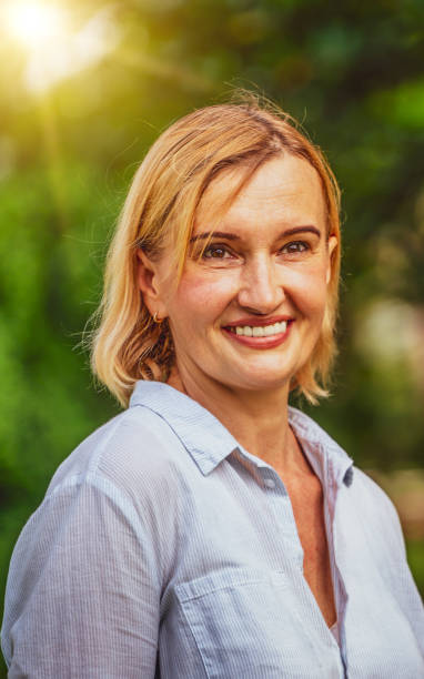 istock Happy middle aged woman standing in the park. 1124293621