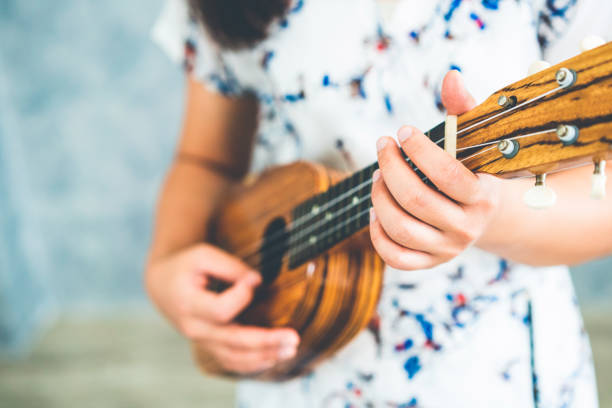 istock Happy woman musician playing ukulele in studio. 1124294698