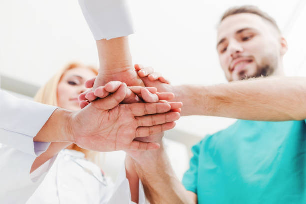 istock Doctor, surgeon and nurse join hands together. 1124298298