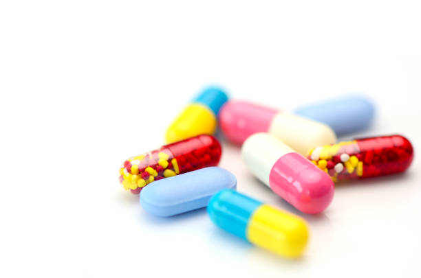 устные лекарства фон с теплым светом - pill multi colored capsule nutritional supplement стоковые фото и изображения