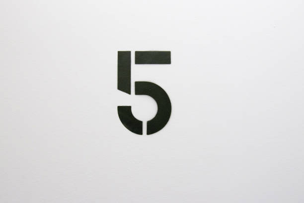 istock Number five stenciled in black paint on white wall 1124311959