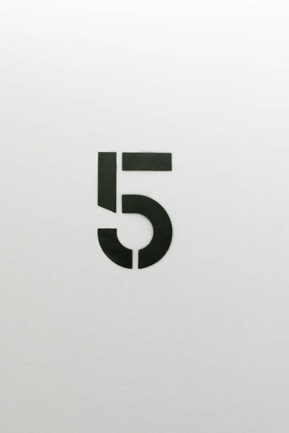 istock Number five stenciled in black paint on white wall 1124311988