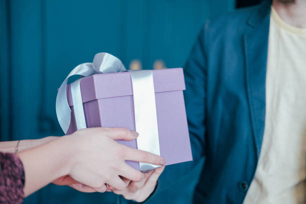 여자 파란색 배경에 젊은 attracrive 남자에서 회색 은색 리본으로 선물 상자를 얻을 - gift ribbon straight wrapped 뉴스 사진 이미지