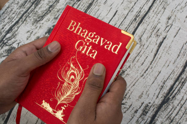 Holding Bhagavad Gita with hands on textured background Maski,Karnataka,India - DECEMBER 29,2018  Holding Bhagavad Gita with hands mahabharata stock pictures, royalty-free photos & images
