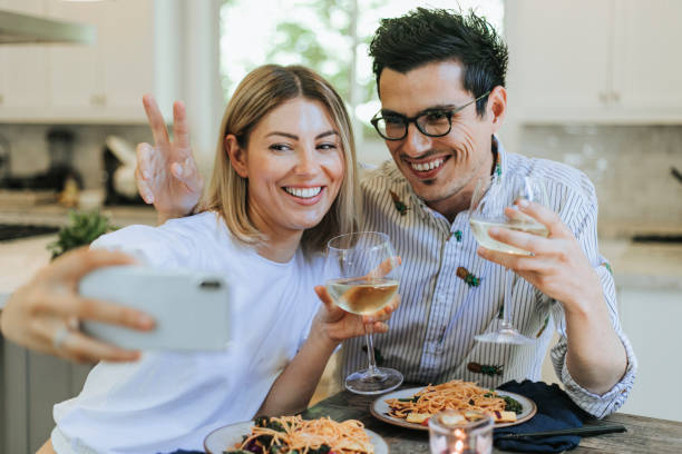 couple taking a selfie during their dinner - food vegan food gourmet vegetarian food imagens e fotografias de stock
