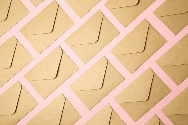 kraft brown paper envelopes on pink background