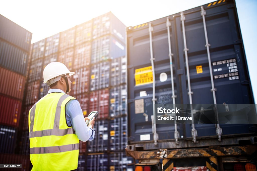 Foreman control loading Containers box from Cargo freight ship for import export, foreman control Industrial Container Cargo freight ship. Logistic concept. Freight Transportation Stock Photo