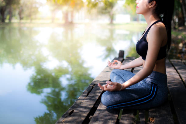 istock young women meditate while doing yoga in atmosphere peaceful. 1124339032