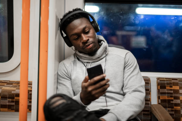 hombre aburridos mensajes de texto mientras en el tren - hora punta temas fotografías e imágenes de stock