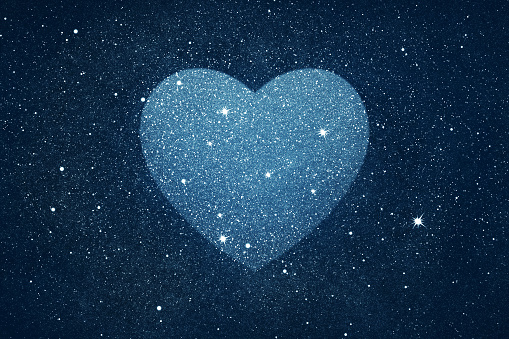 Stars in heart shape over blue night sky background