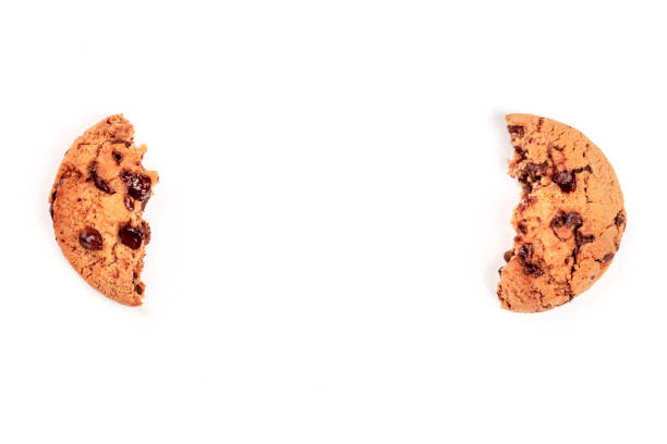 Two halves of a chocolate chip cookie, shot from above on a white background, like brackets, forming a frame for copy space Two halves of a chocolate chip cookie, shot from above on a white background, like brackets, forming a frame for copy space halved stock pictures, royalty-free photos & images