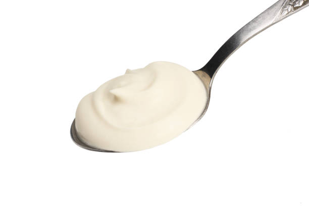 istock sour cream in spoon isolated on white background 1124357102
