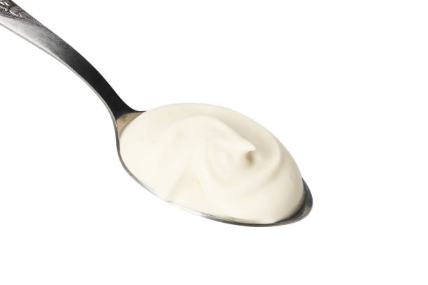 istock sour cream in spoon isolated on white background 1124357105