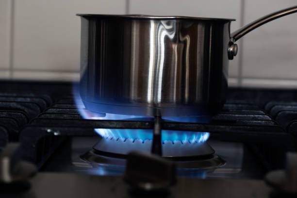 water boiling on a gas stove, stainless pot - blue flame natural gas fireplace imagens e fotografias de stock