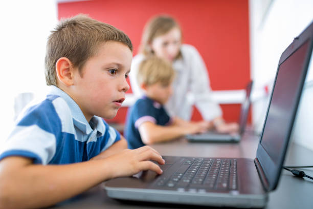 zbliżenie ucznia za pomocą laptopa przy biurku - computer lab child internet development zdjęcia i obrazy z banku zdjęć