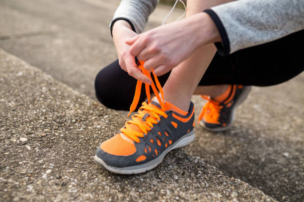 istock young woman trail runner tying shoelaces 1124360998