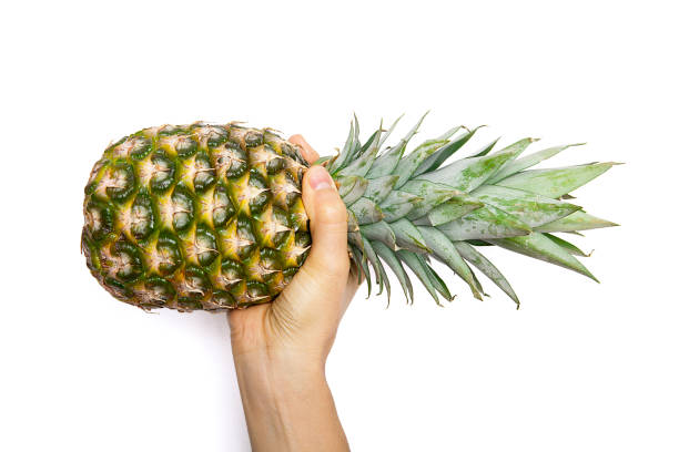 istock Ripe pineapple woman's in hand isolated on white background. 1124362520