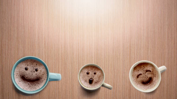 Three different faces coffee cup on a wooden table. stock photo