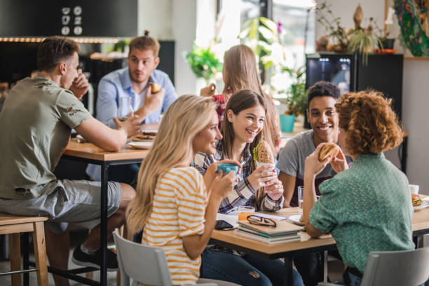istock Happy group of college students communicating during lunch break in cafeteria. 1124368275