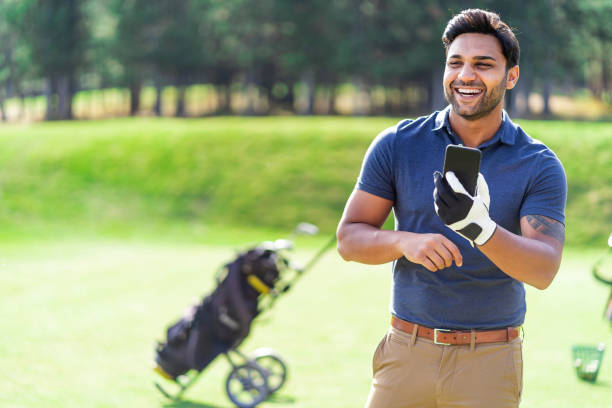 istock Male golfer standing on golf course and using  smart phone 1124371938