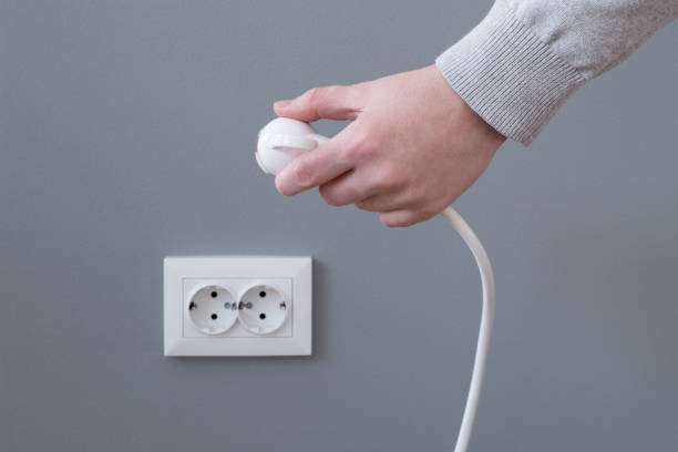 mano inserción eléctrica enchufe enchufe - electric plug outlet pulling electricity fotografías e imágenes de stock