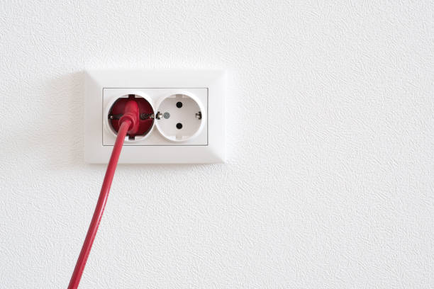 istock Power cord cable plugged into wall outlet 1124375543