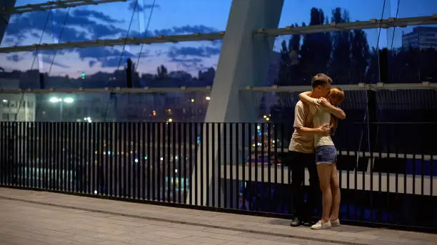 Couple hugging near shopping center on summer evening, romantic feelings, love