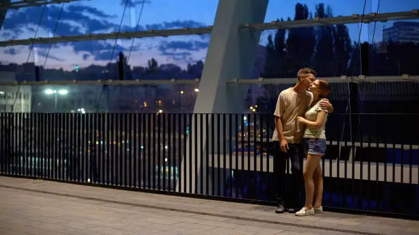 Young couple kissing and hugging on summer evening, romantic feelings, love