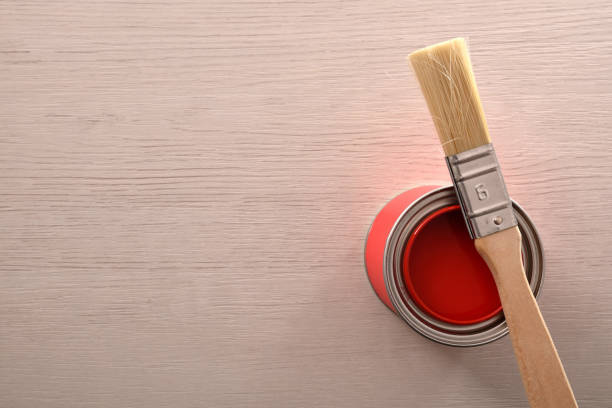 istock Can of red paint opened with brush over on table 1124381771