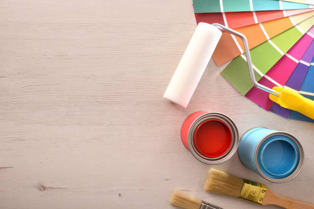 istock Two open paint cans and tools on wooden table top 1124381812